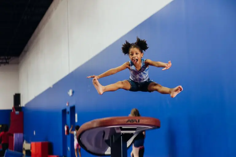 Little girl jumping in air during gymnastics class at Dominique Dawes Academy