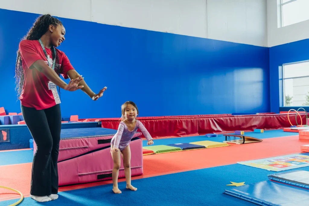 Gymnastics coach with junior gymnast