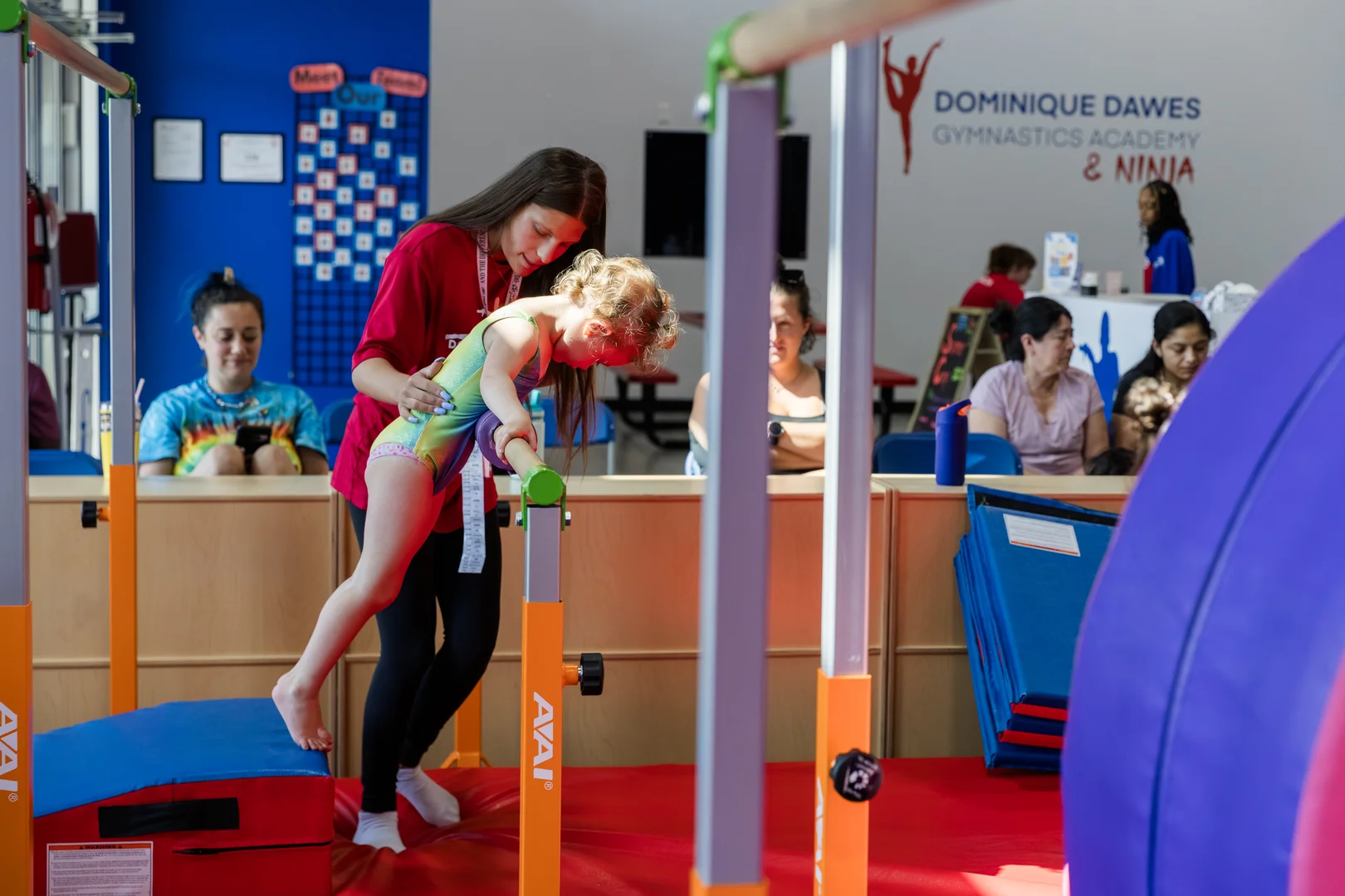 Coach training gymnast on bars