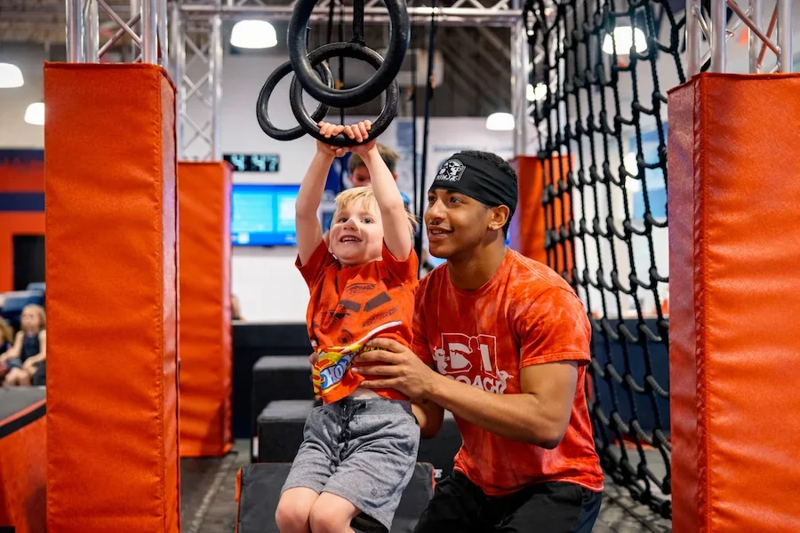 Dominique Dawes gymnastics coach teaches little boy during Ninja Class