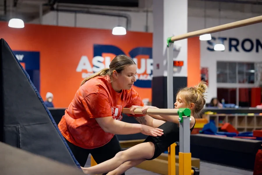Dominique Dawes gymnastics coach teaches little girl bar gymnastics