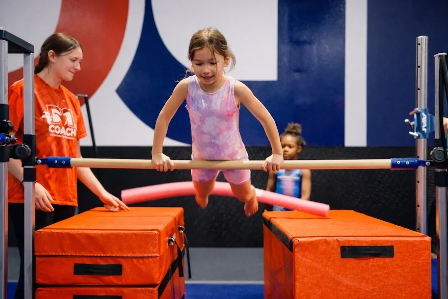 Dominique Dawes gymnastics coach teaches little girl bar gymnastics